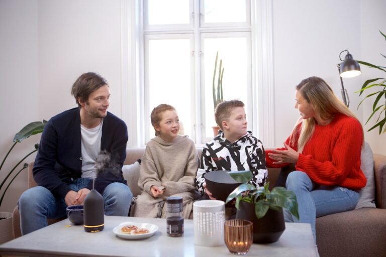 A parent and child sitting together on a living room couch, talking and listening attentively.